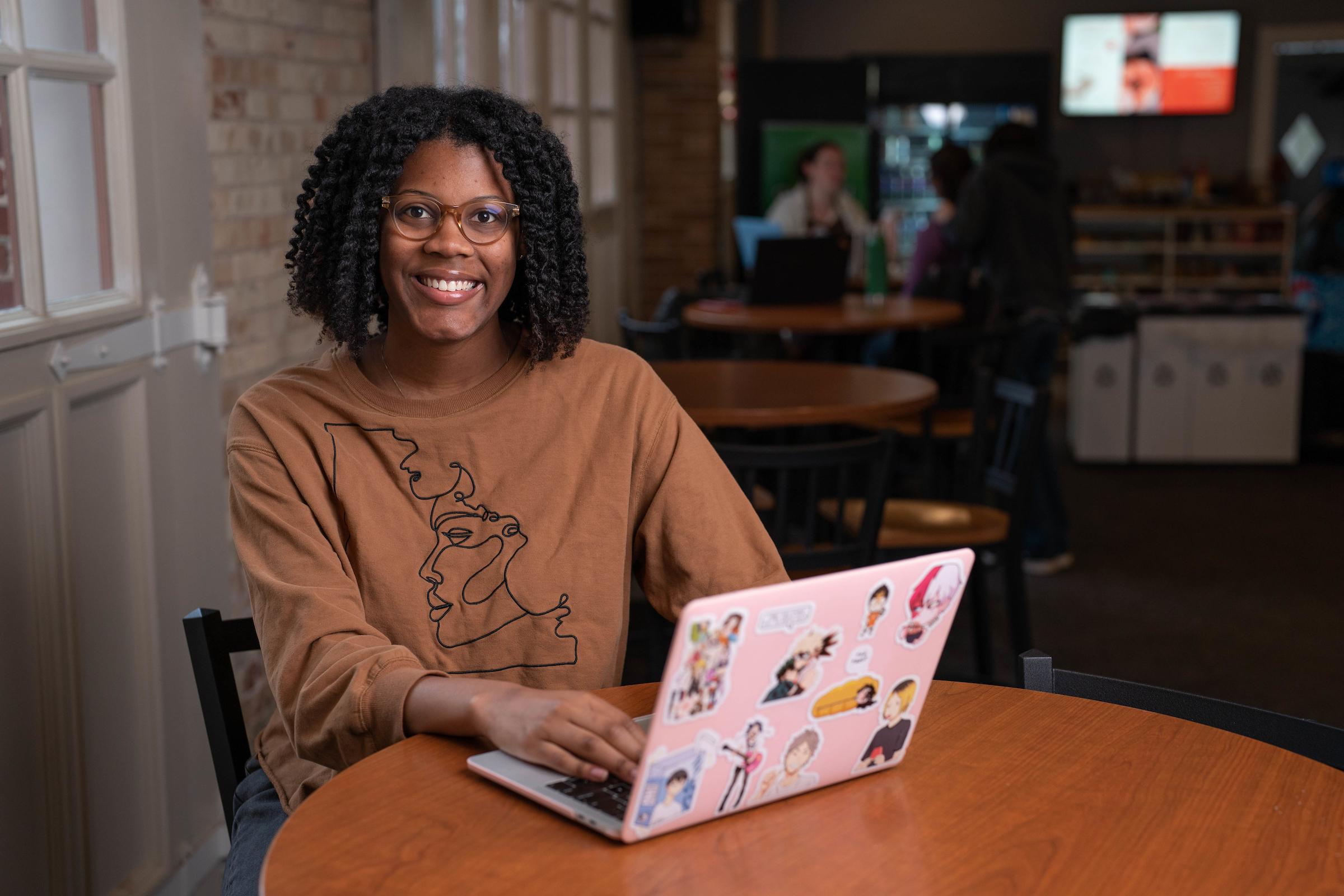 Macayla Jones working on a laptop at a table at The Moose